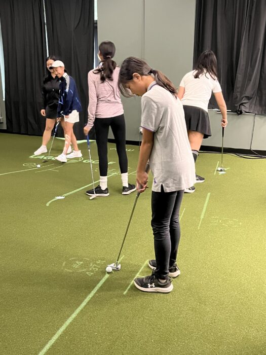 Junior golfers practising putting in a group lesson at Lago Golf's PuttView studio in Port Coquitlam
