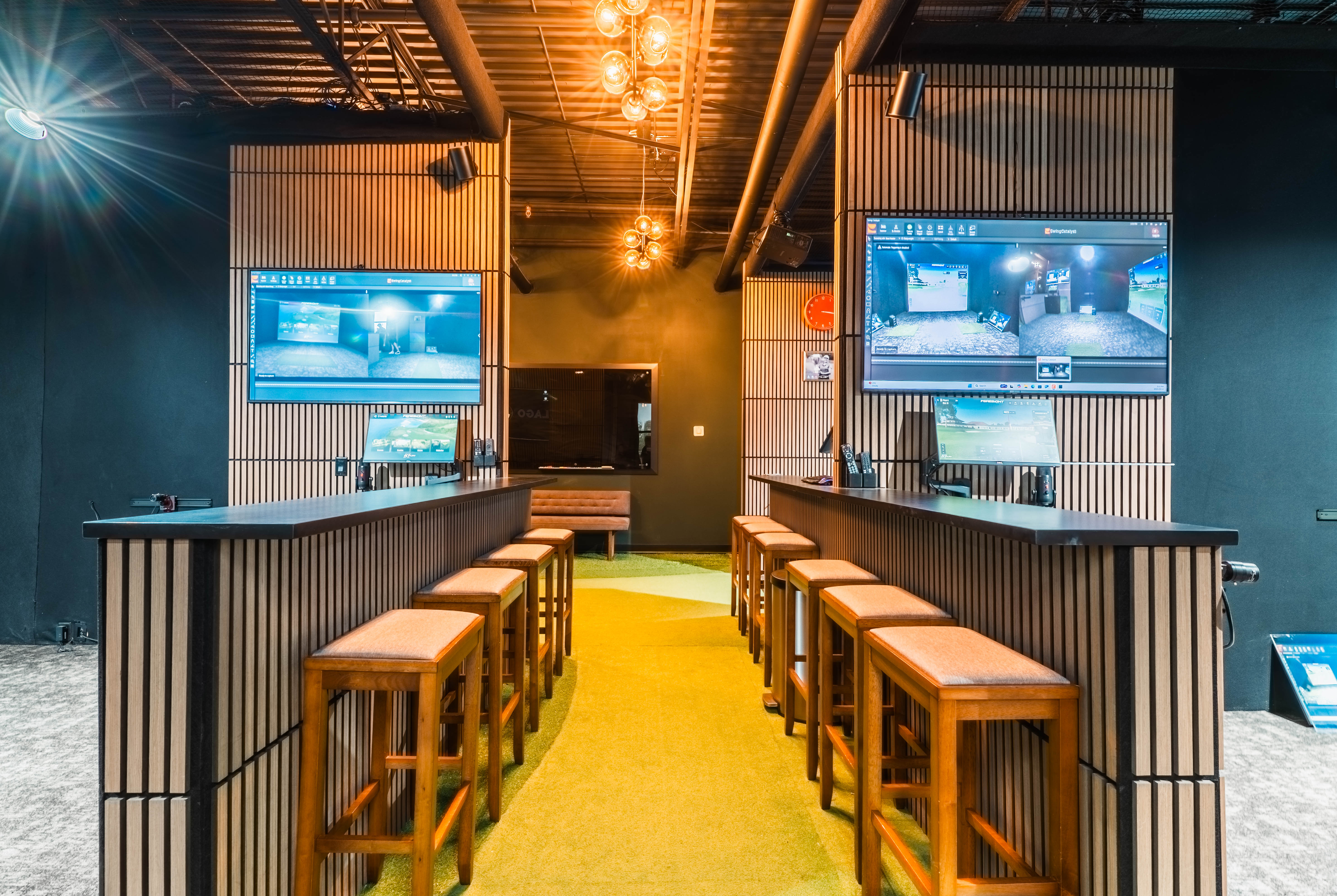 The Loft at Lago Golf, with bar-height seating between indoor golf simulator bays