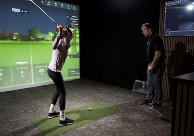 Junior golfer receiving a private golf lesson in an indoor simulator bay at Lago Golf in Port Coquitlam