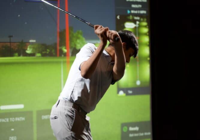 Junior golfer practising in Lago Golf's indoor simulator bay, included with a junior golf membership in Port Coquitlam